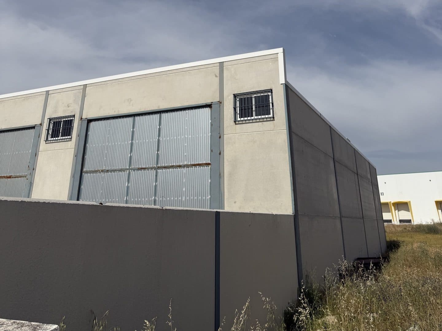 Vista del volumen de las naves industriales adosadas con cerramiento de hormigón en Moguer